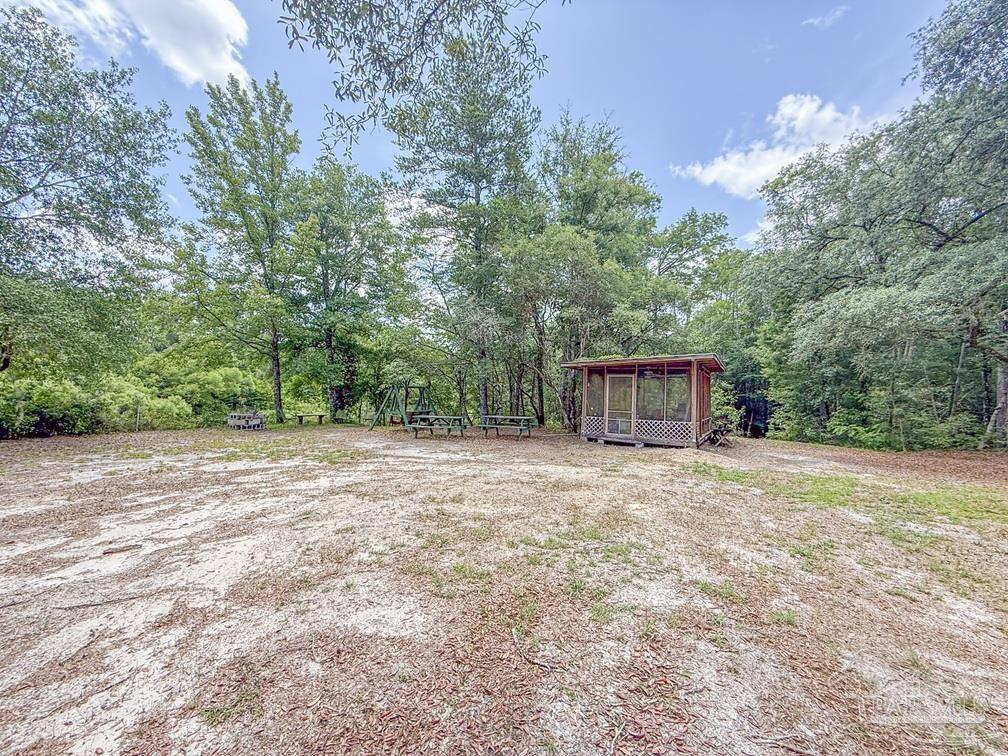 4020 Easy Street Holt, FL 32564 - Photo 19 of 19 a backyard of a house with trees and outdoor space