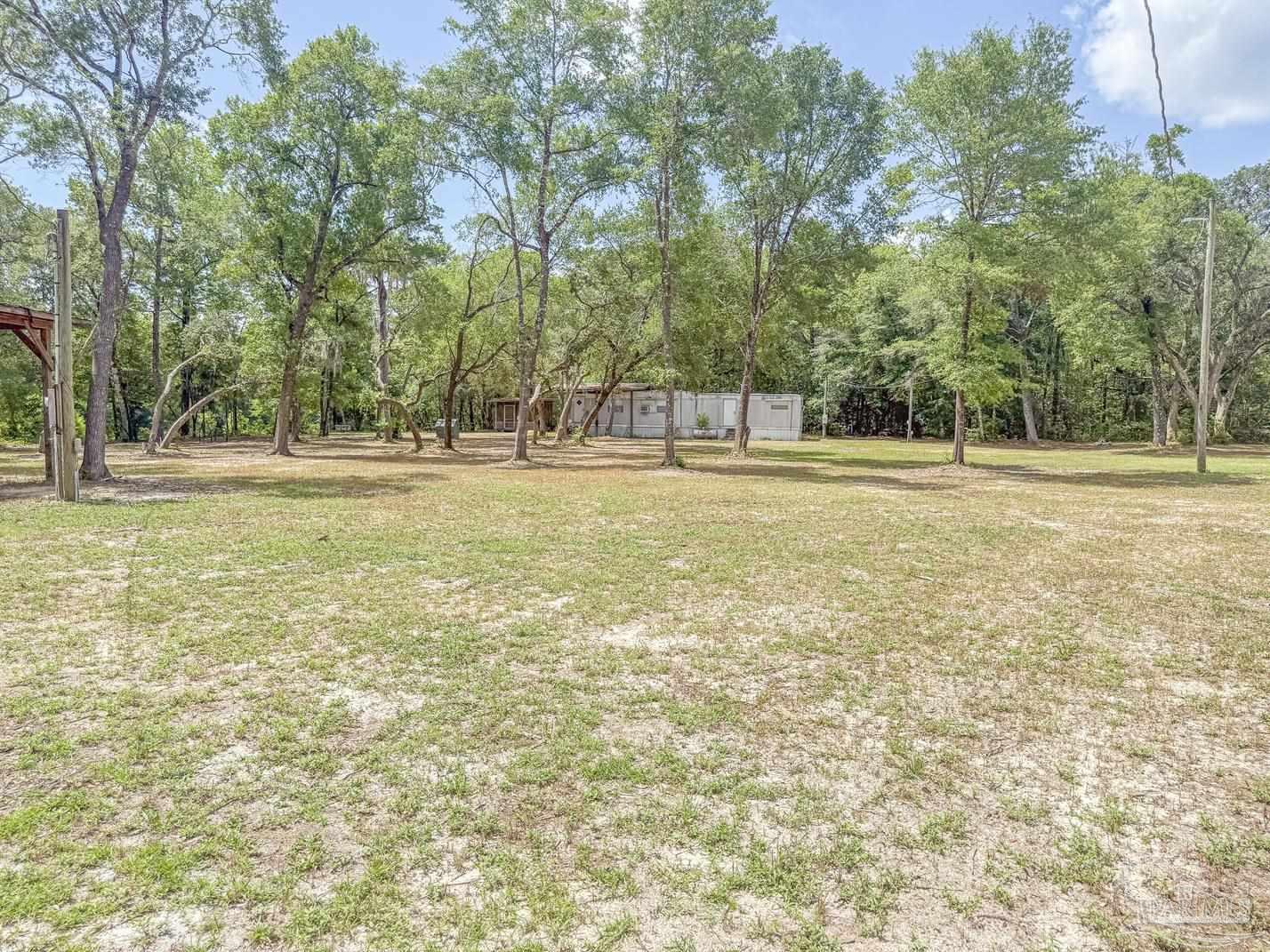 4020 Easy Street Holt, FL 32564 - Photo 7 of 19 a view of a field with trees in the background