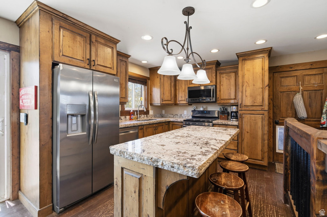 781 West 3000 South Heber City, UT 84032 - Photo 8 of 30 Kitchen with stainless steel appliances, hanging light fixtures, a kitchen island, wood finish cabinets, and a breakfast bar