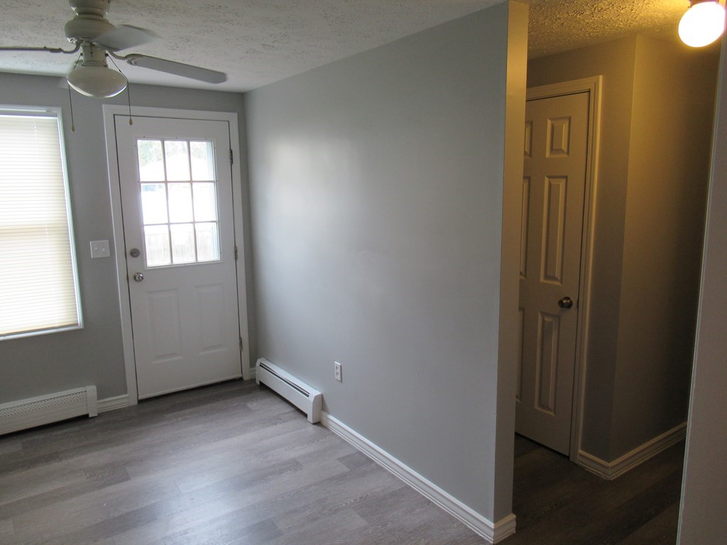 30 Clayton Street, Unit E Springfield, MA 01107 - Photo 6 of 27 an empty room with wooden floor cabinet and windows