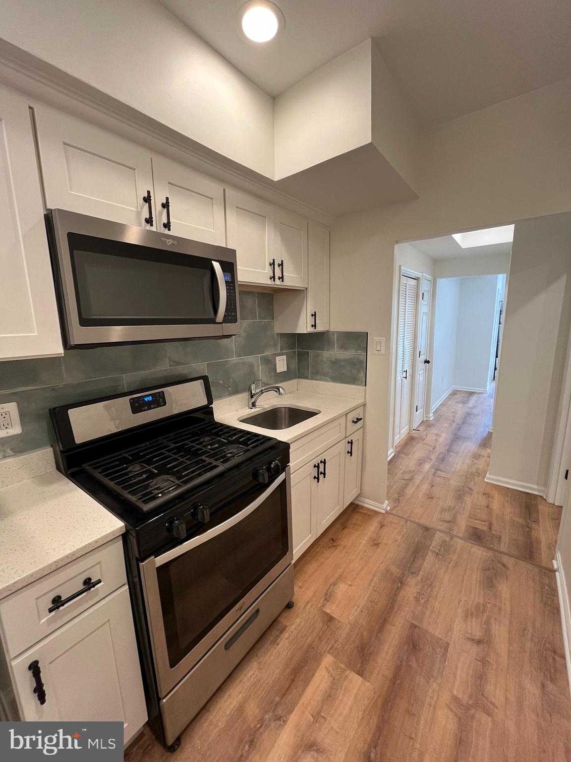 1718 West Virginia Avenue Northeast, Unit 1 Washington, DC 20002 - Photo 4 of 12 a kitchen with stainless steel appliances a stove a microwave and cabinets