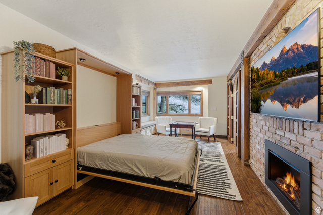 2687 Stewart Road Sundance, UT 84604 - Photo 15 of 48 Bedroom with a brick fireplace and dark wood-type flooring