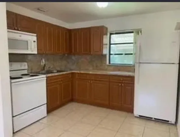 a kitchen with a cabinets and white appliances