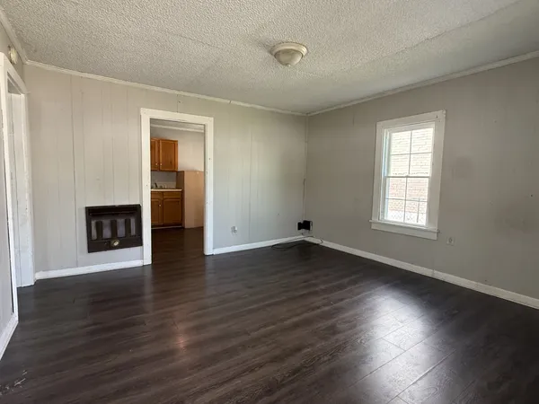 a view of empty room with wooden floor and fireplace