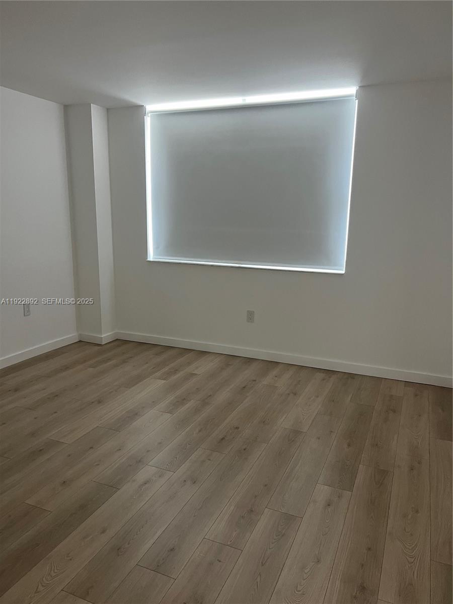 1155 Brickell Bay Drive, Unit 3205 Miami, FL 33131 - Photo 12 of 14 an empty room with wooden floor and windows