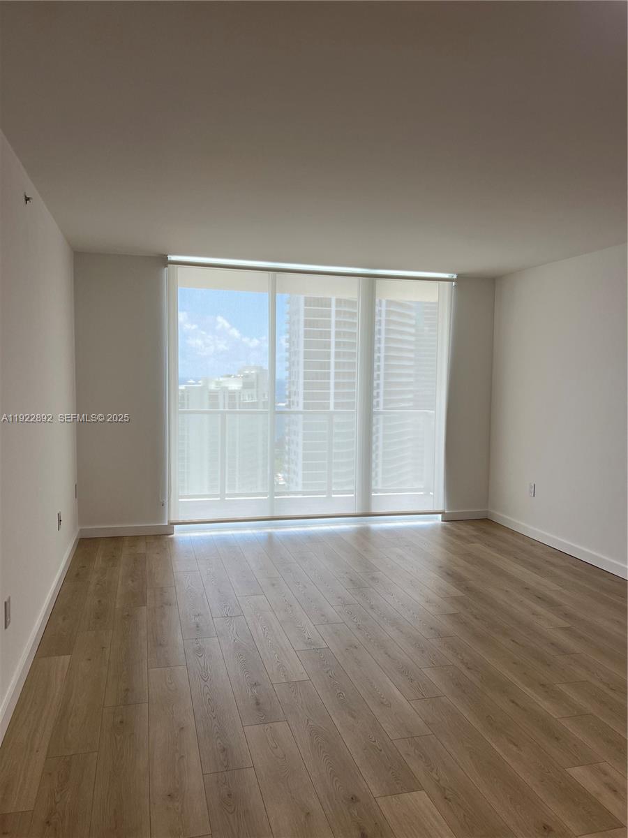 1155 Brickell Bay Drive, Unit 3205 Miami, FL 33131 - Photo 13 of 14 wooden floor in an empty room with a window