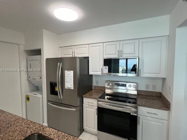 a kitchen with stainless steel appliances granite countertop a refrigerator stove and microwave