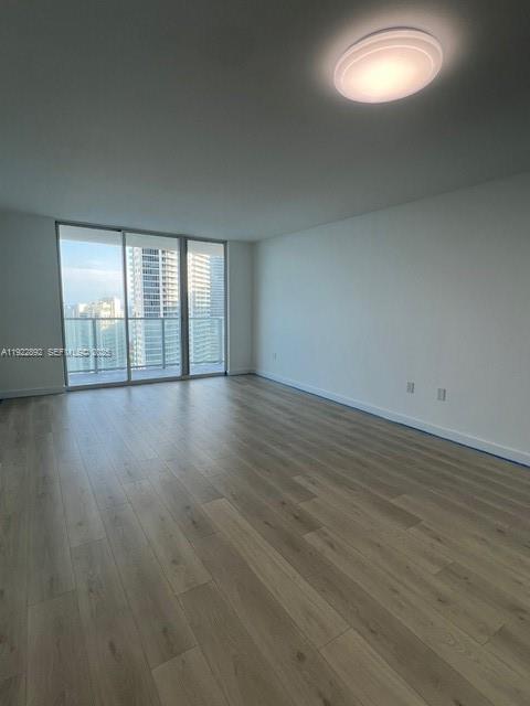 1155 Brickell Bay Drive, Unit 3205 Miami, FL 33131 - Photo 7 of 14 an empty room with wooden floor and windows