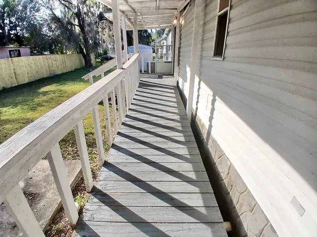 a view of a balcony with wooden floor and fence