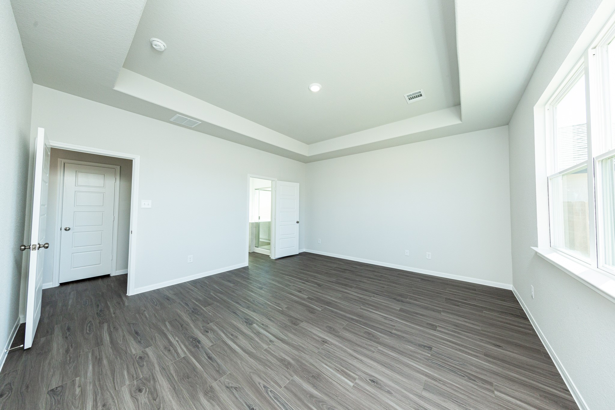 15627 Tranquil Pines Street Conroe, TX 77302 - Photo 12 of 27 an empty room with wooden floor and windows