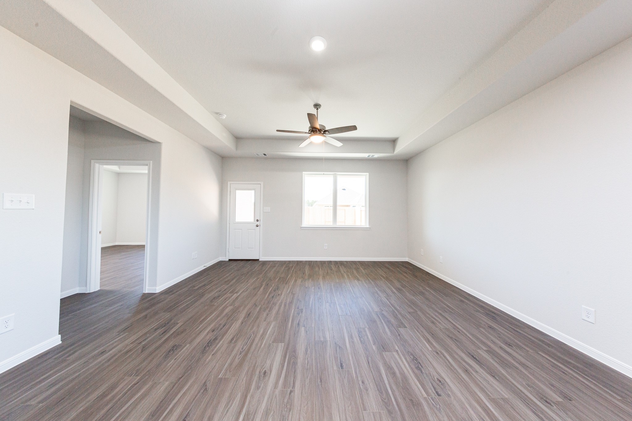 15627 Tranquil Pines Street Conroe, TX 77302 - Photo 9 of 27 an empty room with wooden floor and windows