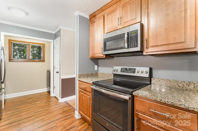 a kitchen with granite countertop a stove microwave and sink