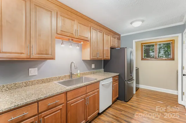 a kitchen with stainless steel appliances granite countertop a refrigerator sink and cabinets