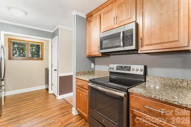 a kitchen with granite countertop a stove microwave and sink