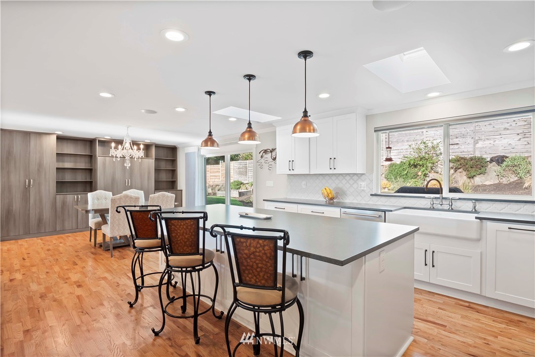 10404 Northeast 197th Street Bothell, WA 98011 - Photo 12 of 29 a kitchen with stainless steel appliances a table chairs sink and cabinets
