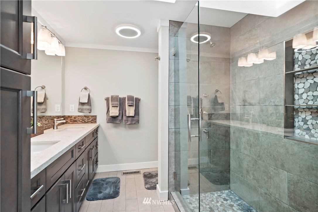 10404 Northeast 197th Street Bothell, WA 98011 - Photo 26 of 29 a bathroom with a double vanity sink a toilet a mirror and shower