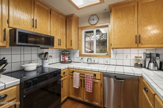 a kitchen with stainless steel appliances granite countertop a sink stove and cabinets