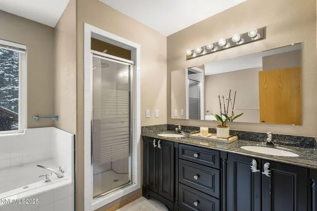 a bathroom with a granite countertop sink mirror and a bathtub
