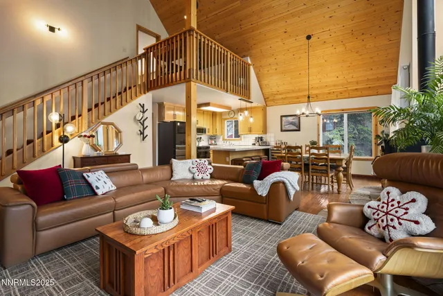 a living room with furniture a large window and a chandelier