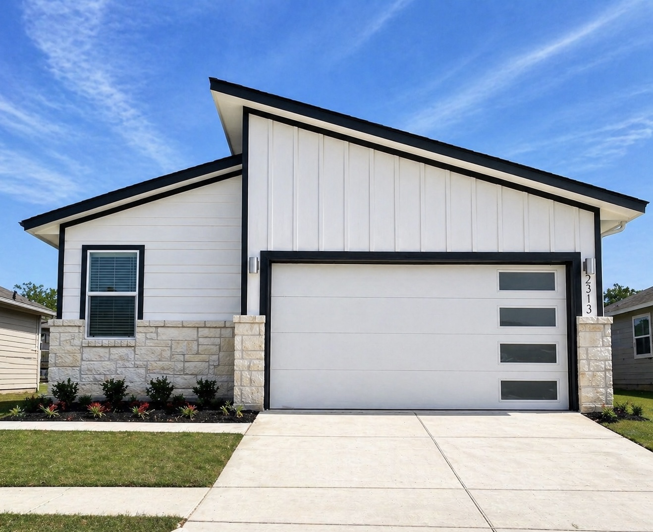 Modern architecture featuring white siding with black trim, a sloped roofline, and a stone facade accent