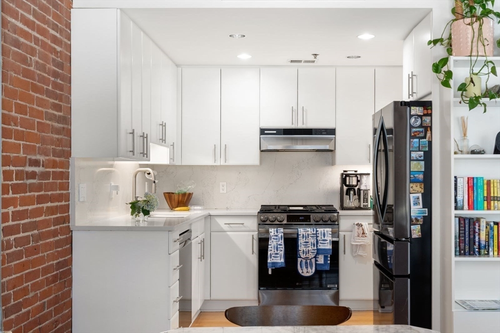 9 West Broadway, Unit 314 Boston, MA 02127 - Photo 11 of 25 a kitchen with stainless steel appliances granite countertop a refrigerator and a sink