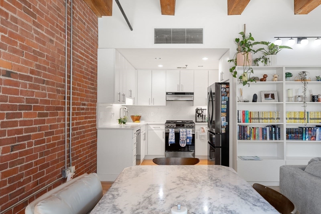 9 West Broadway, Unit 314 Boston, MA 02127 - Photo 12 of 25 a kitchen with stainless steel appliances a refrigerator and a stove top oven