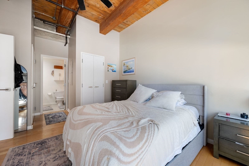 9 West Broadway, Unit 314 Boston, MA 02127 - Photo 16 of 25 a bedroom with a bed and a chandelier