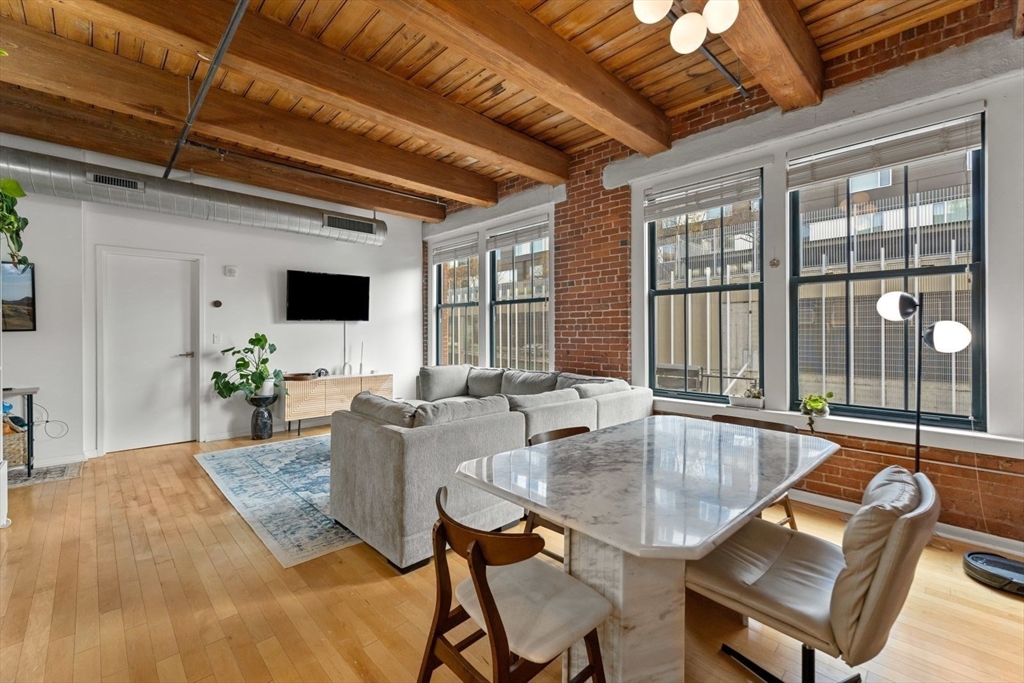 9 West Broadway, Unit 314 Boston, MA 02127 - Photo 2 of 25 a dining room with furniture floor to ceiling windows and potted plants