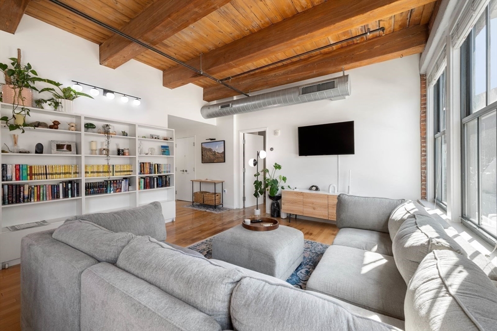 9 West Broadway, Unit 314 Boston, MA 02127 - Photo 5 of 25 a living room with furniture and a flat screen tv