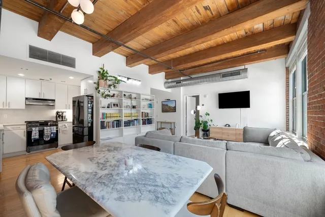 a kitchen with stainless steel appliances granite countertop a sink a stove a refrigerator and white cabinets