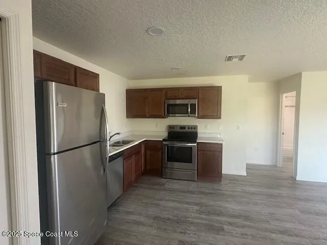 a kitchen with stainless steel appliances granite countertop a refrigerator stove a sink and dishwasher