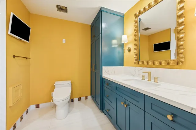a bathroom with a granite countertop toilet sink and mirror
