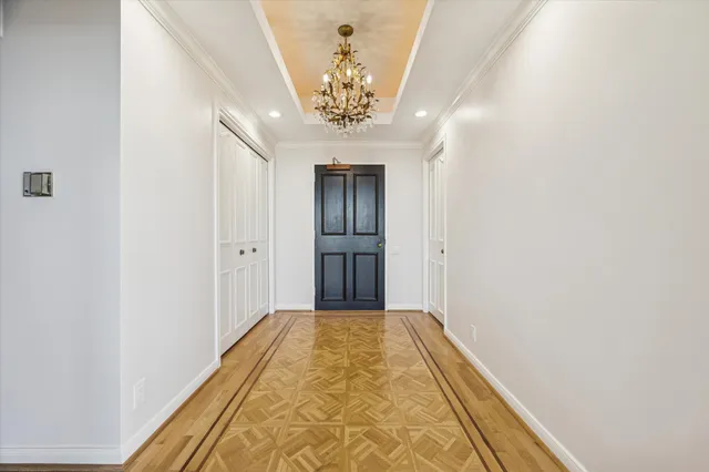 a view of a hallway with a chandelier fan and wooden floor