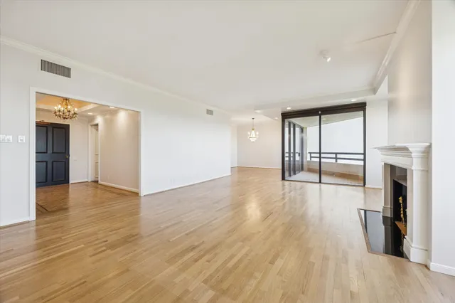 a view of a big room with wooden floor and a kitchen