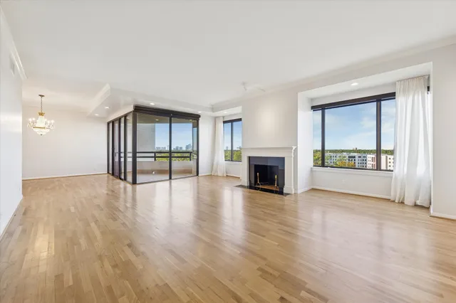 wooden floor fireplace and windows in an empty room