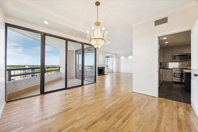 a view of a big room with wooden floor kitchen view and windows