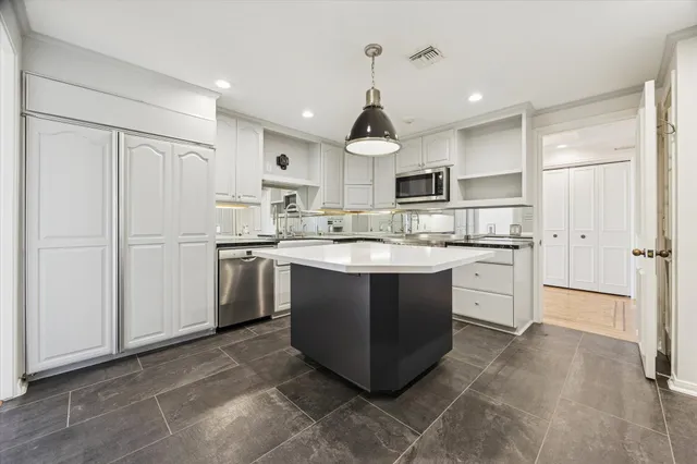 a kitchen with stainless steel appliances granite countertop a sink a stove a refrigerator and a refrigerator