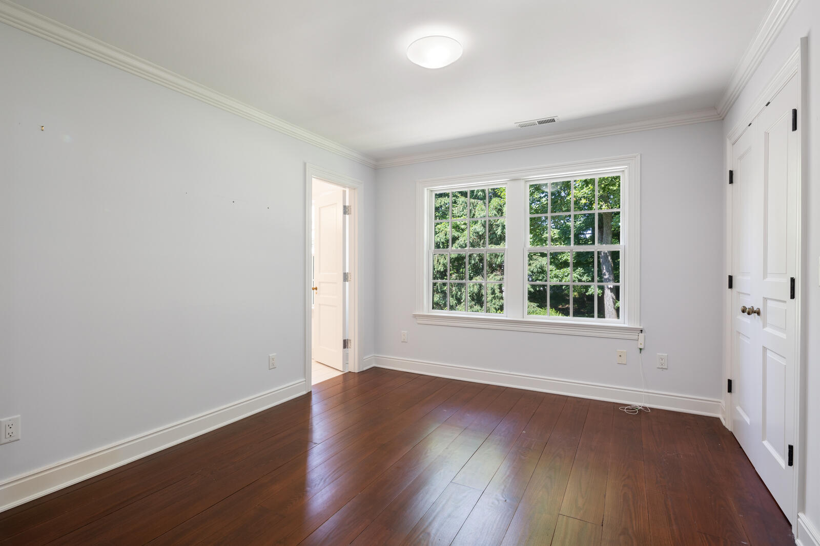 1446 Ponus Ridge Road New Canaan, CT 06840 - Photo 19 of 25 an empty room with wooden floor and windows