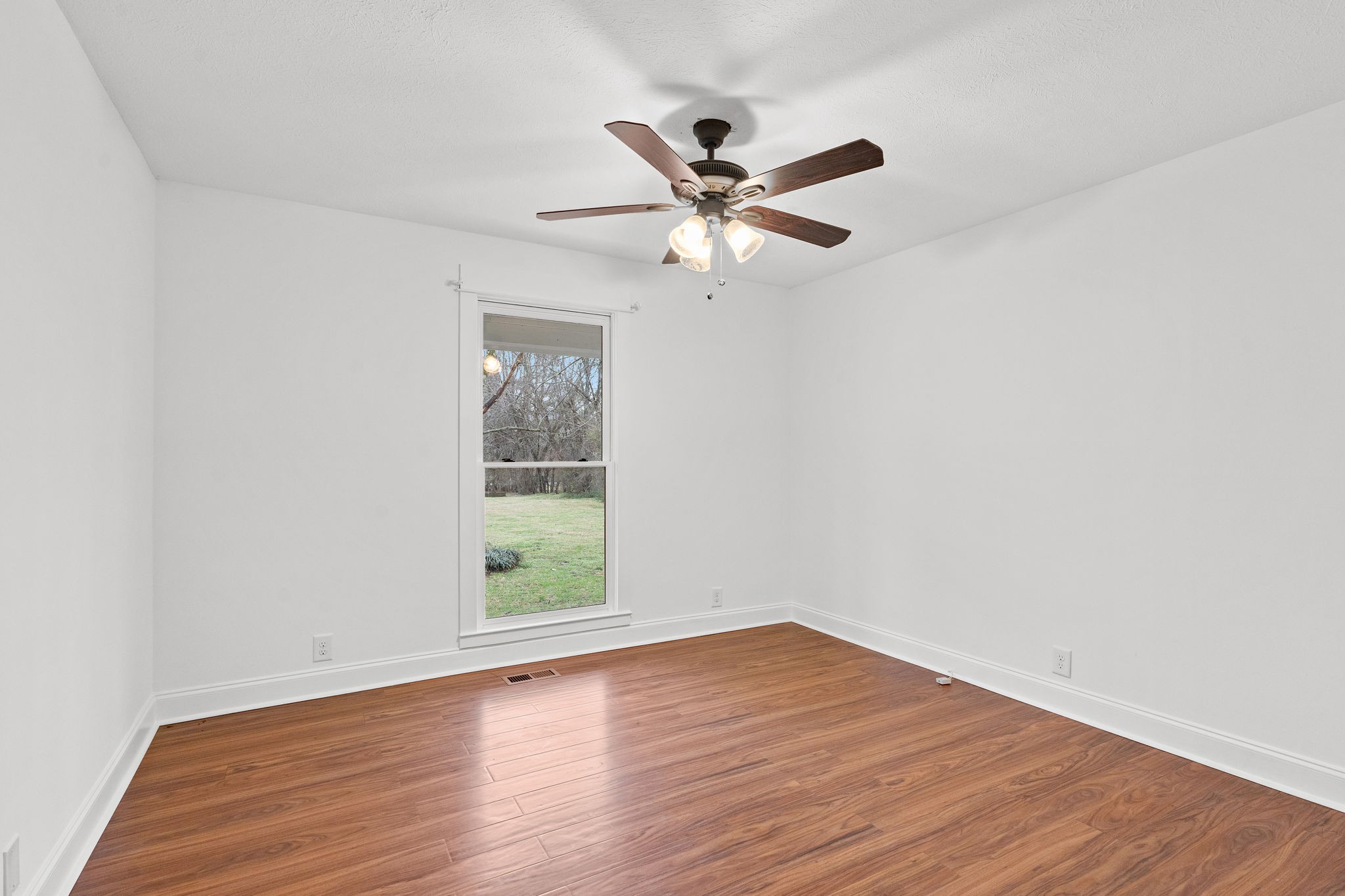 4462 Harpeth School Road Franklin, TN 37064 - Photo 29 of 45 an empty room with wooden floor fan and windows