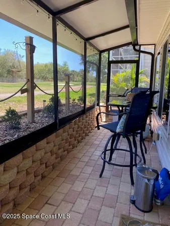 a bedroom with a bed and large windows
