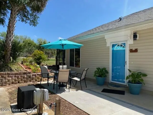 a view of a house with potted plants and a yard