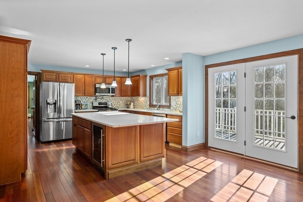 277 Sawyer Road Bolton, MA 01740 - Photo 13 of 41 a kitchen with stainless steel appliances granite countertop a stove a refrigerator a sink and a oven with wooden floor