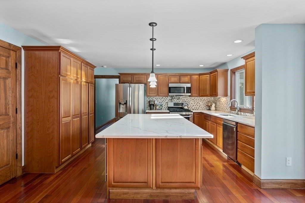 277 Sawyer Road Bolton, MA 01740 - Photo 14 of 41 a kitchen with stainless steel appliances granite countertop a refrigerator a sink dishwasher a stove and white countertops with wooden floor