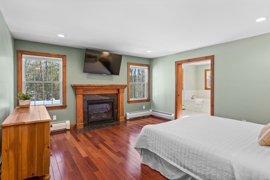 277 Sawyer Road Bolton, MA 01740 - Photo 18 of 41 a bedroom with a bed and a fireplace