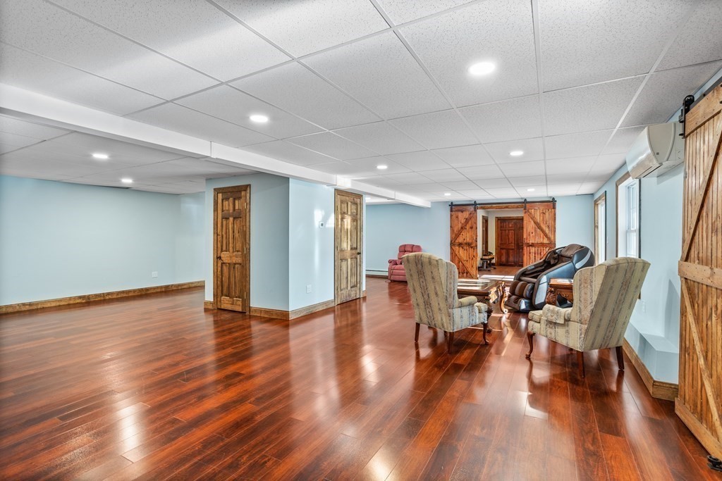 277 Sawyer Road Bolton, MA 01740 - Photo 29 of 41 a living room with furniture and a wooden floor