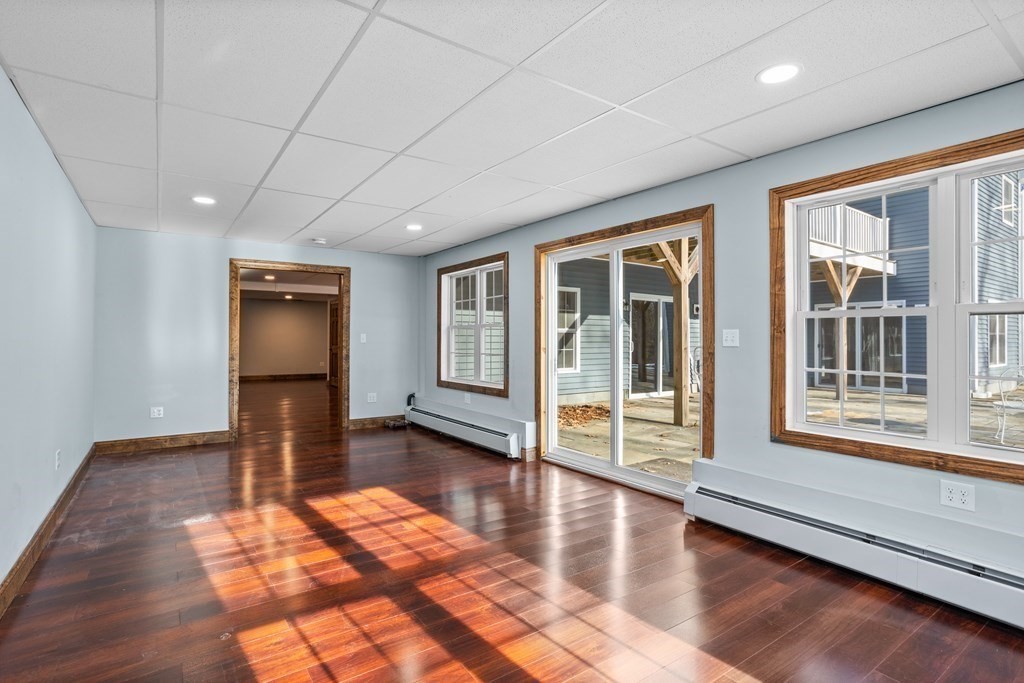 277 Sawyer Road Bolton, MA 01740 - Photo 34 of 41 a view of empty room with wooden floor and floor to ceiling window