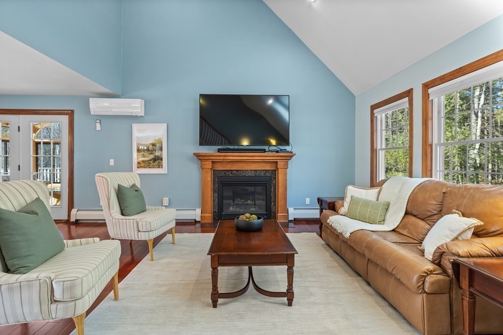 277 Sawyer Road Bolton, MA 01740 - Photo 6 of 41 a living room with furniture a fireplace and a flat screen tv