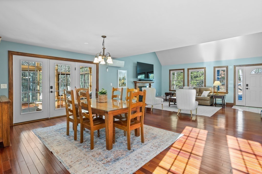 277 Sawyer Road Bolton, MA 01740 - Photo 8 of 41 a dining room with wooden floor a chandelier a wooden table and chairs
