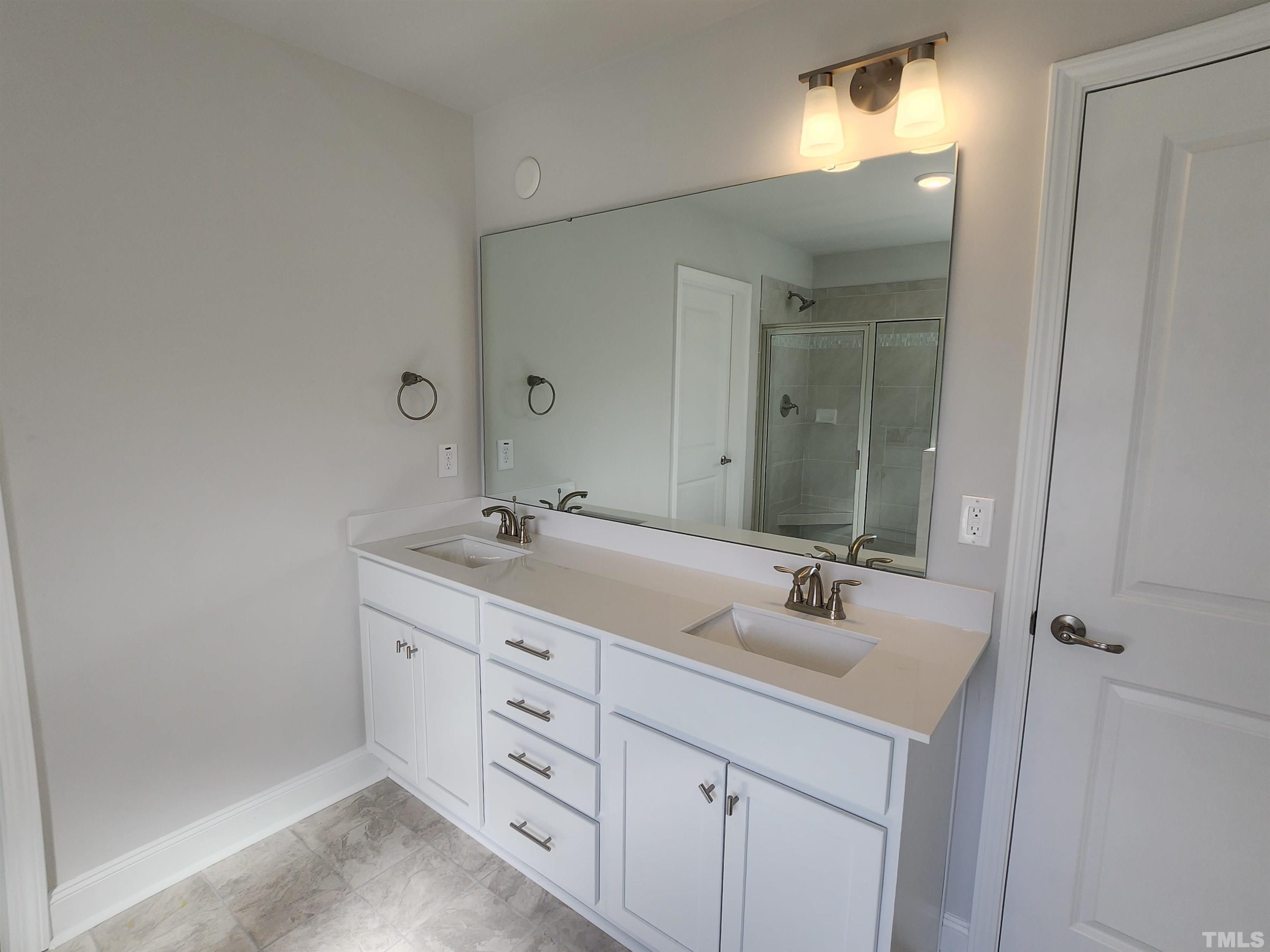 243 Spring Flowers Drive Cameron, NC 28326 - Photo 14 of 30 a bathroom with a double vanity sink and a mirror