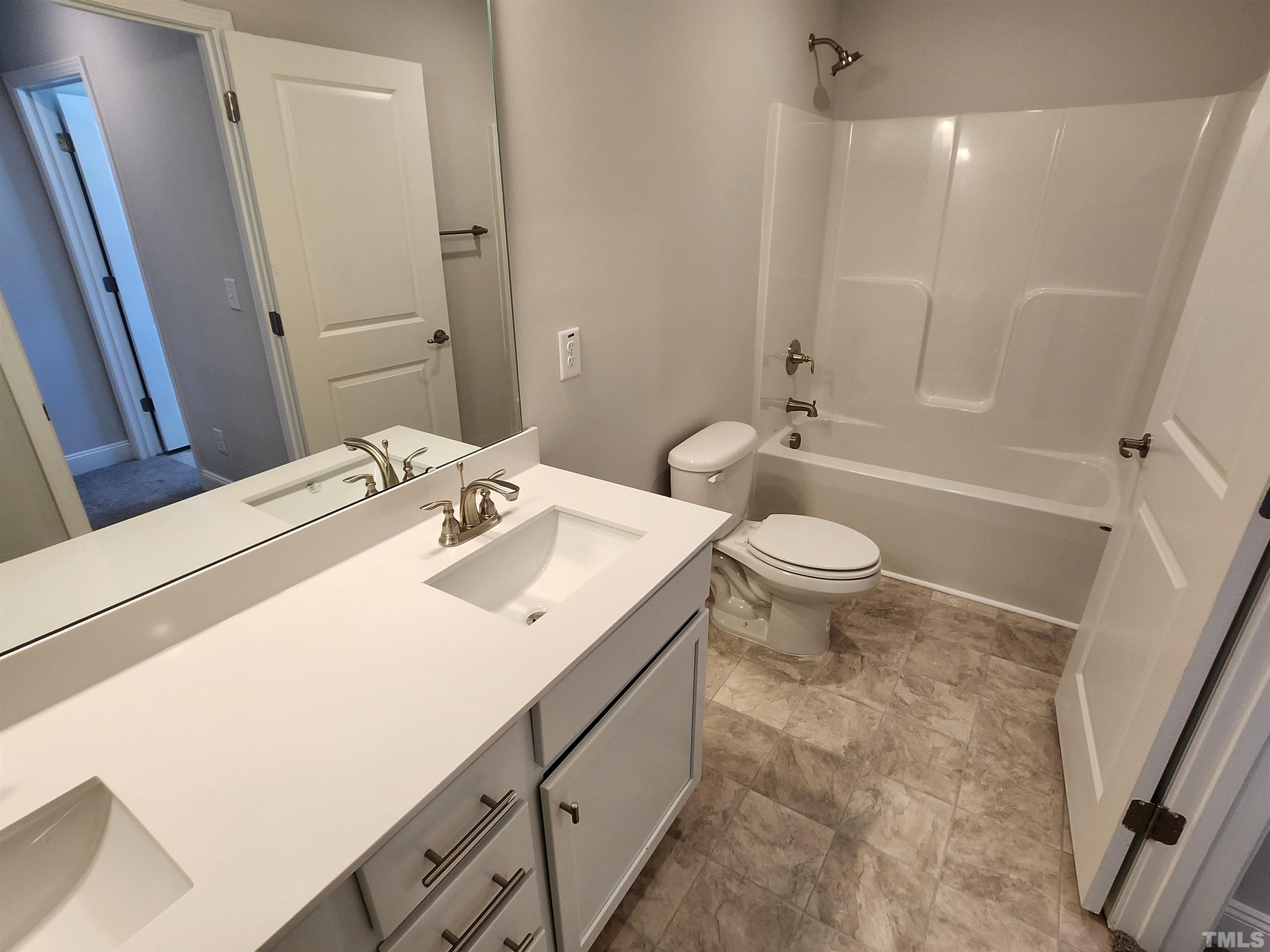 243 Spring Flowers Drive Cameron, NC 28326 - Photo 18 of 30 a bathroom with a sink a toilet a mirror and shower